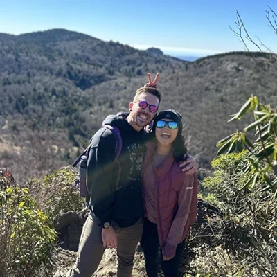 Alejandra Suarez and Jake Coldren smiling in the mountains.